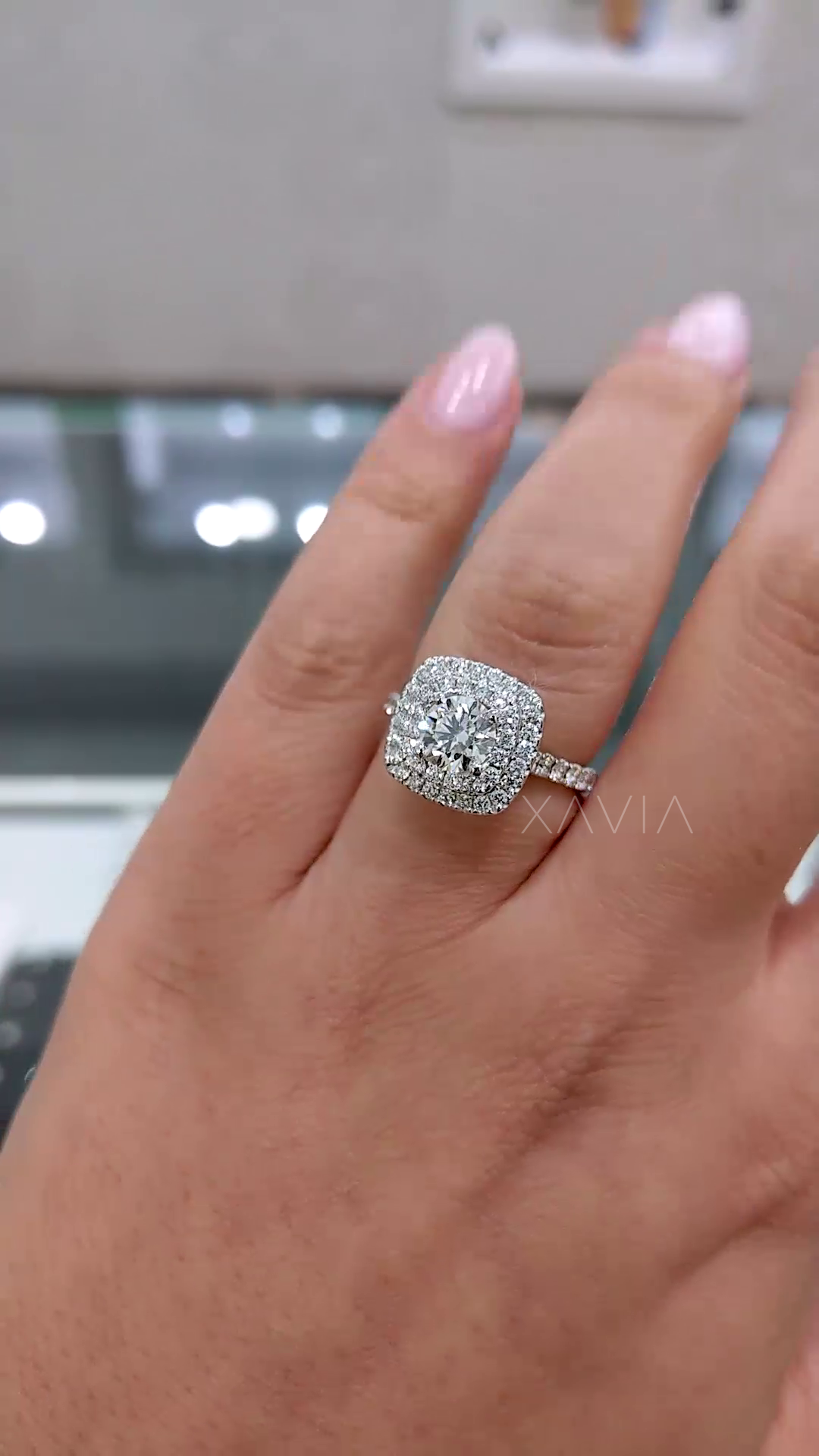 close up of cushion halo lab diamond ring showcasing round brilliant center stone surrounded by two rows of shimmering pavé diamonds