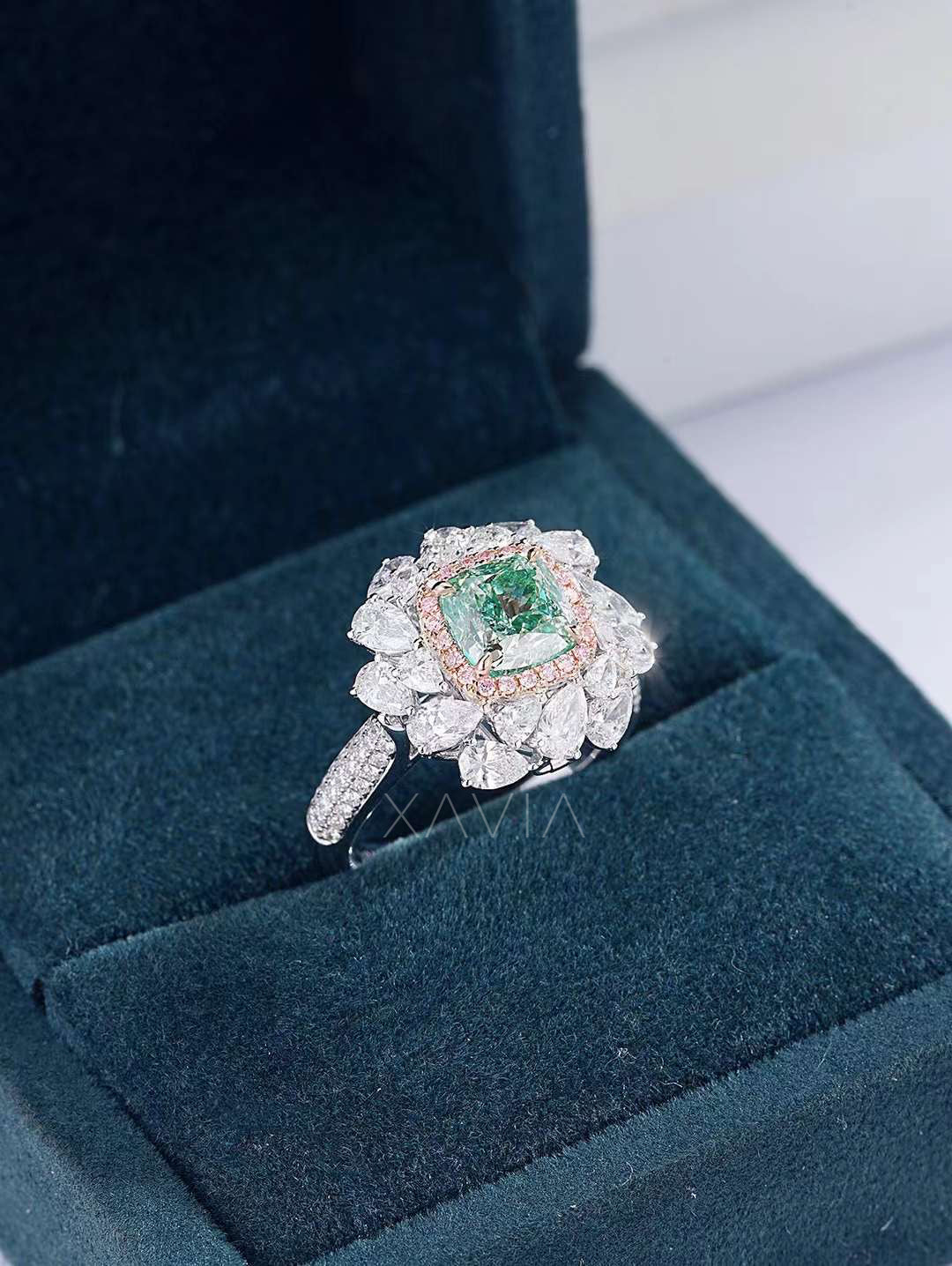emerald green cushion diamond ring with pink and pear halo inside velvet jewelry box