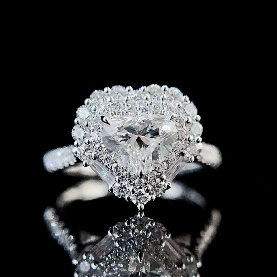 High magnification image of heart shaped center diamond ring with halo clusters and baguette side stones reflecting intense brilliance under studio lighting