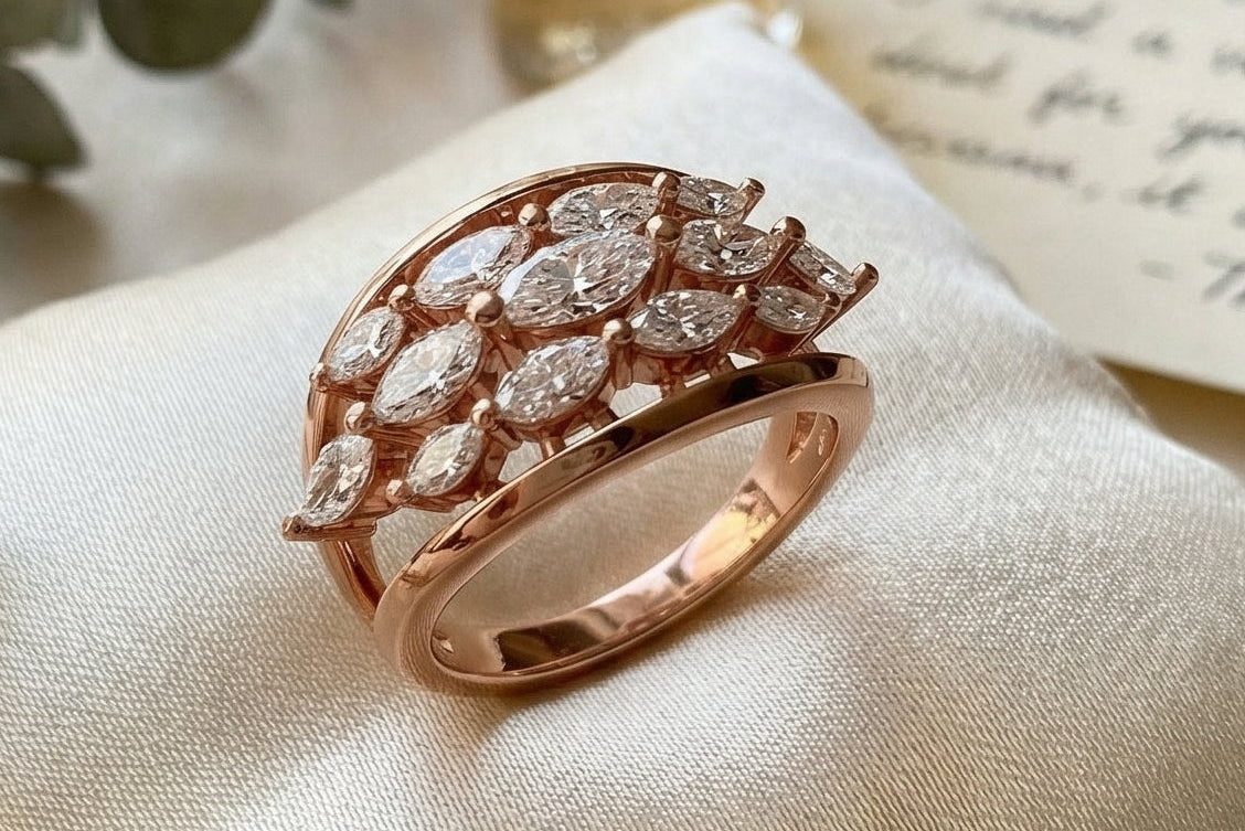 lifestyle photograph of rose gold marquise diamond cluster ring worn on hand beside flowers emphasizing romantic luxury jewelry styling