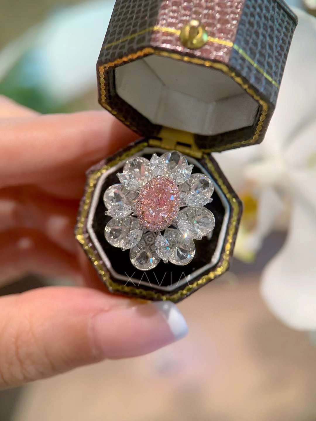 luxury floral-inspired diamond ring with pink center stone shown inside ring box