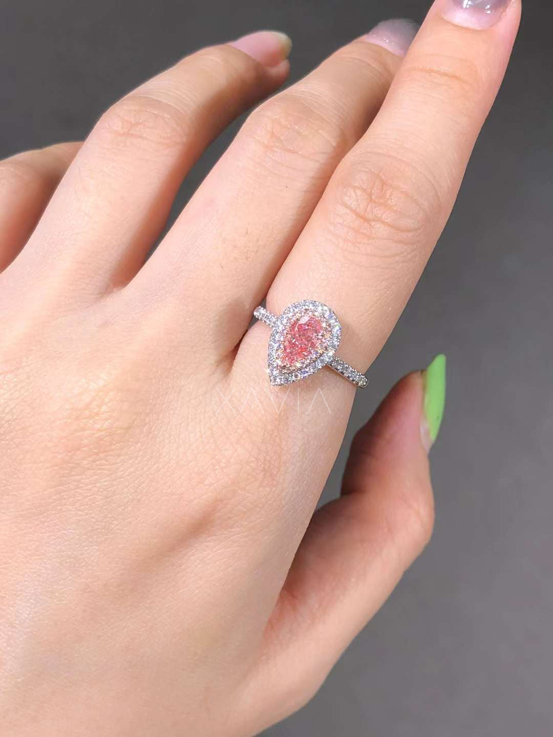 pear-shaped pink lab diamond ring sparkling on model’s hand