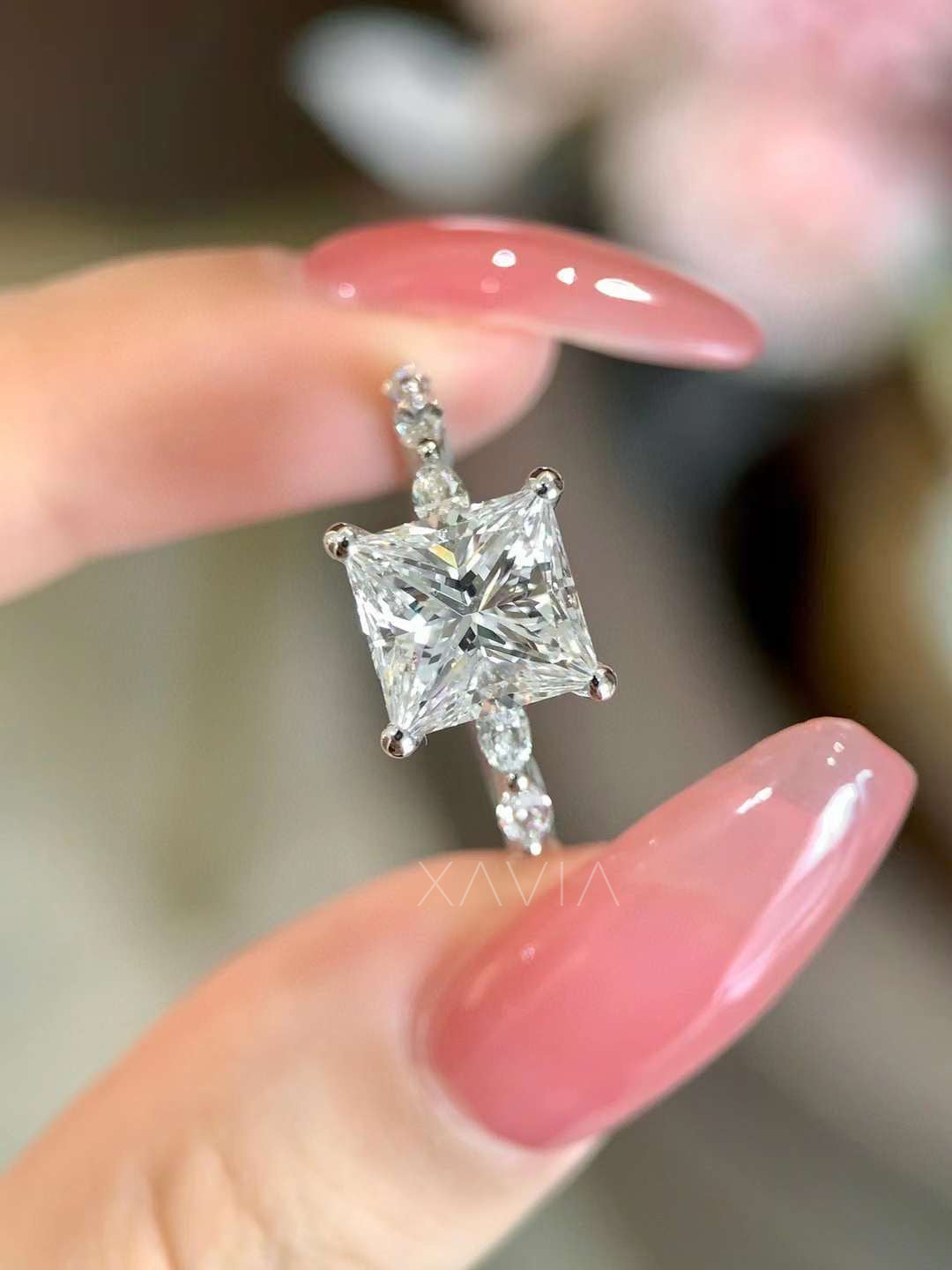 Angled close-up view of a princess cut lab-grown diamond engagement ring with marquise accent diamonds along the band displaying high brilliance and modern elegance