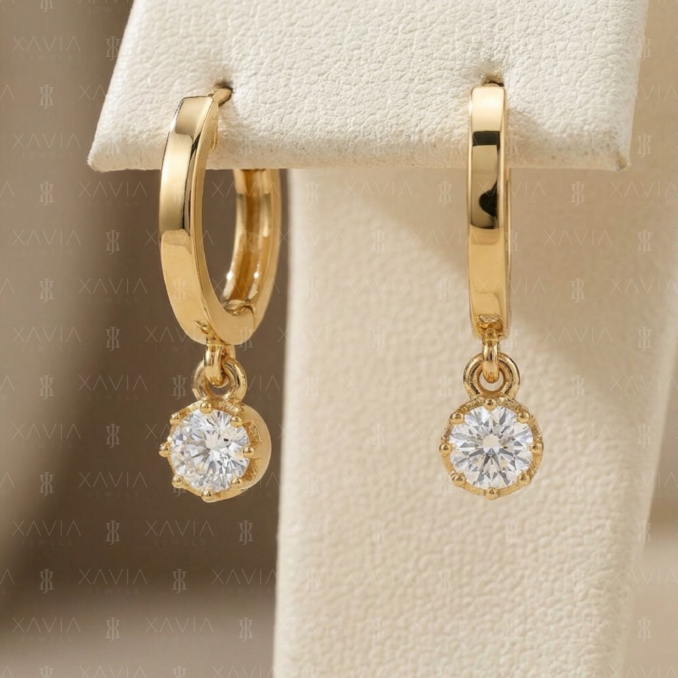 Display shot of sleek yellow gold hoop earrings featuring suspended round lab-grown diamond solitaire drops with clean modern minimalist jewelry styling.