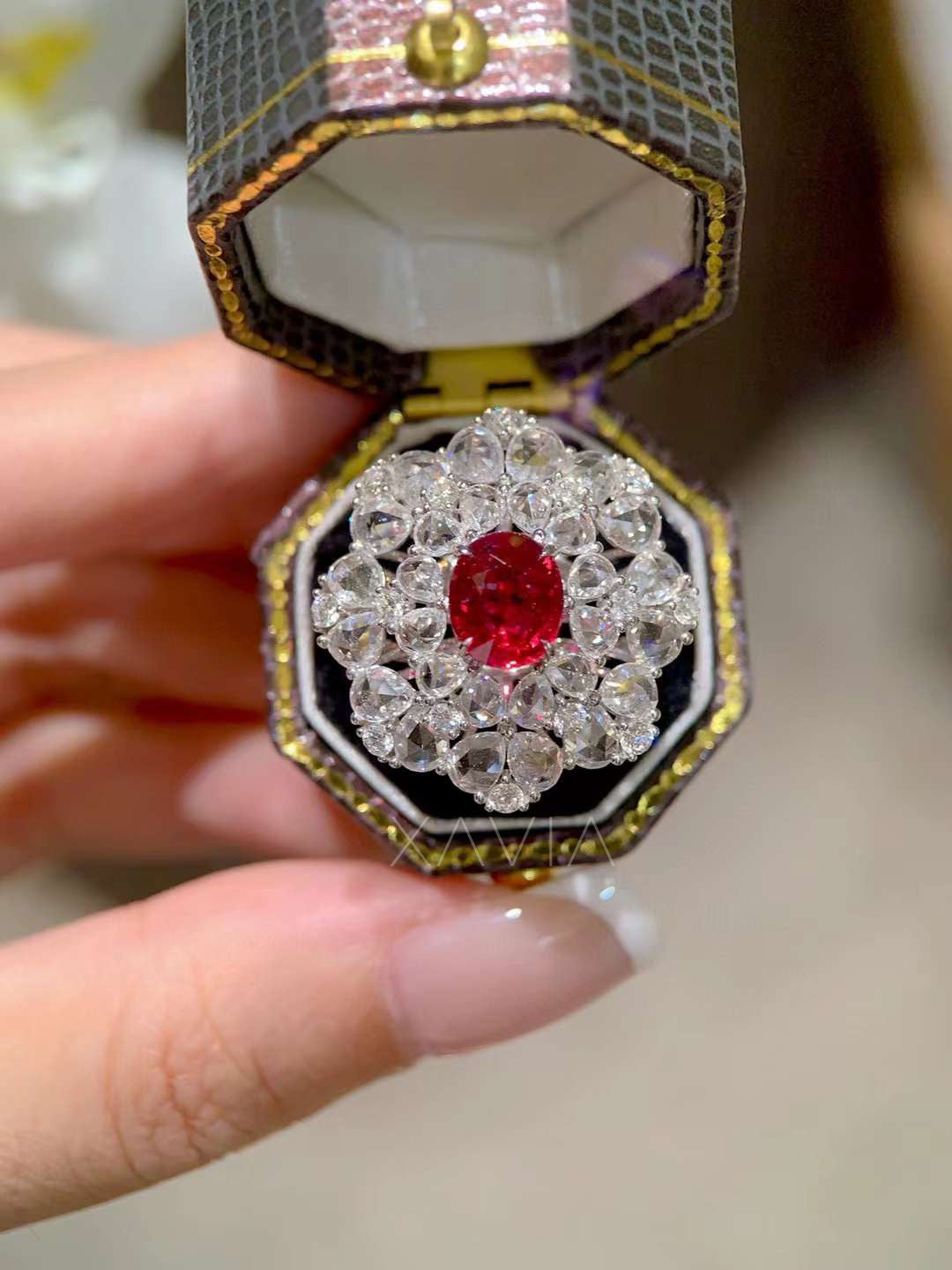 Ruby center diamond floral cluster cocktail ring photographed in a luxury presentation box highlighting brilliant sparkle and dramatic gemstone contrast