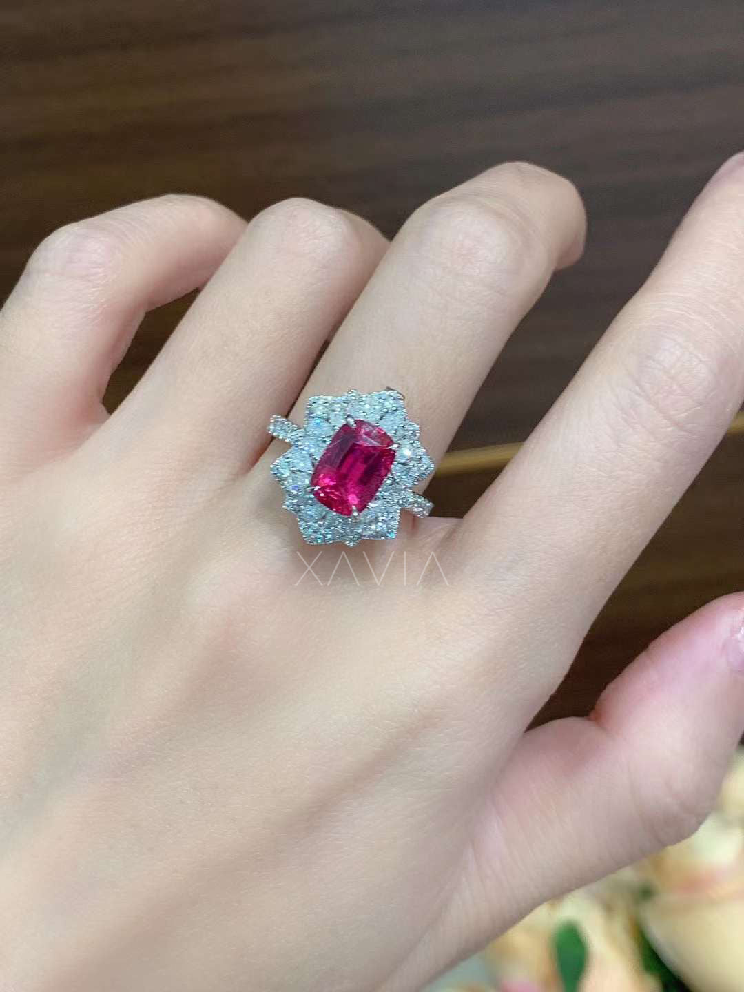 Ruby diamond halo ring showcased in vintage black and gold octagonal jewelry box with floral-inspired diamond halo