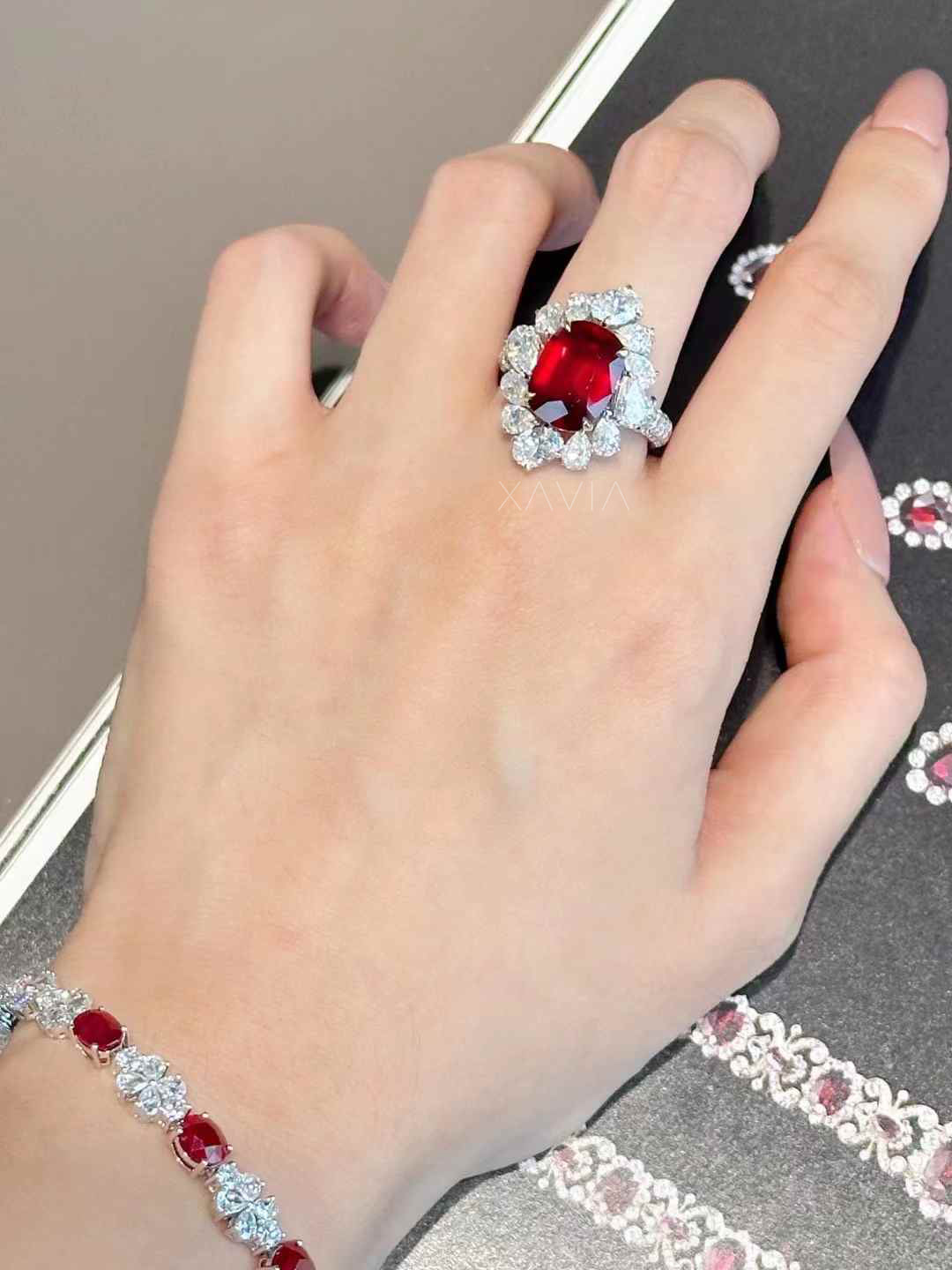 Angled perspective of cushion cut ruby red halo diamond ring highlighting depth, brilliance, and floral diamond arrangement