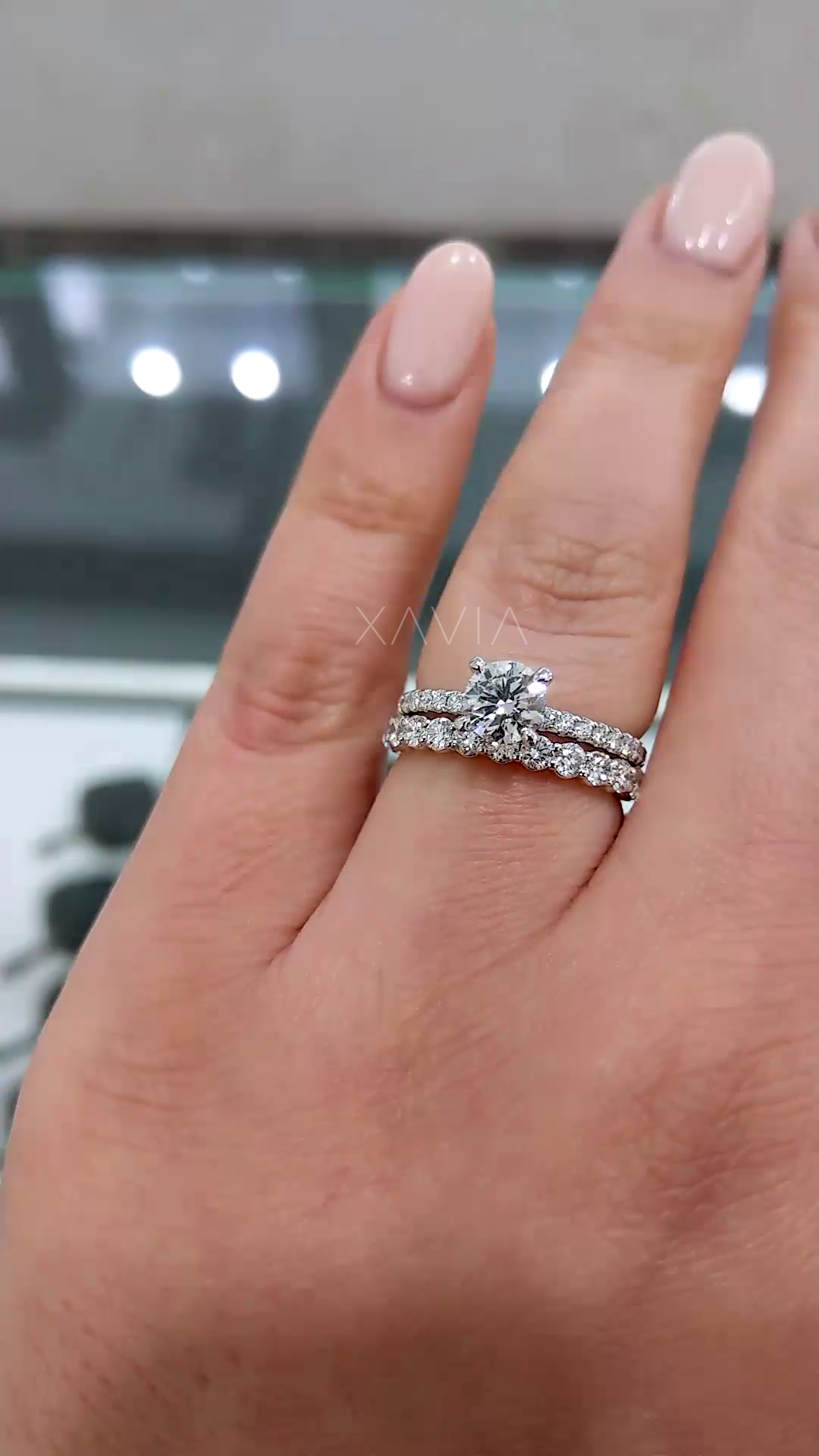 luxury round diamond solitaire engagement ring paired with curved pavé band creating elegant stacked bridal set with continuous sparkle