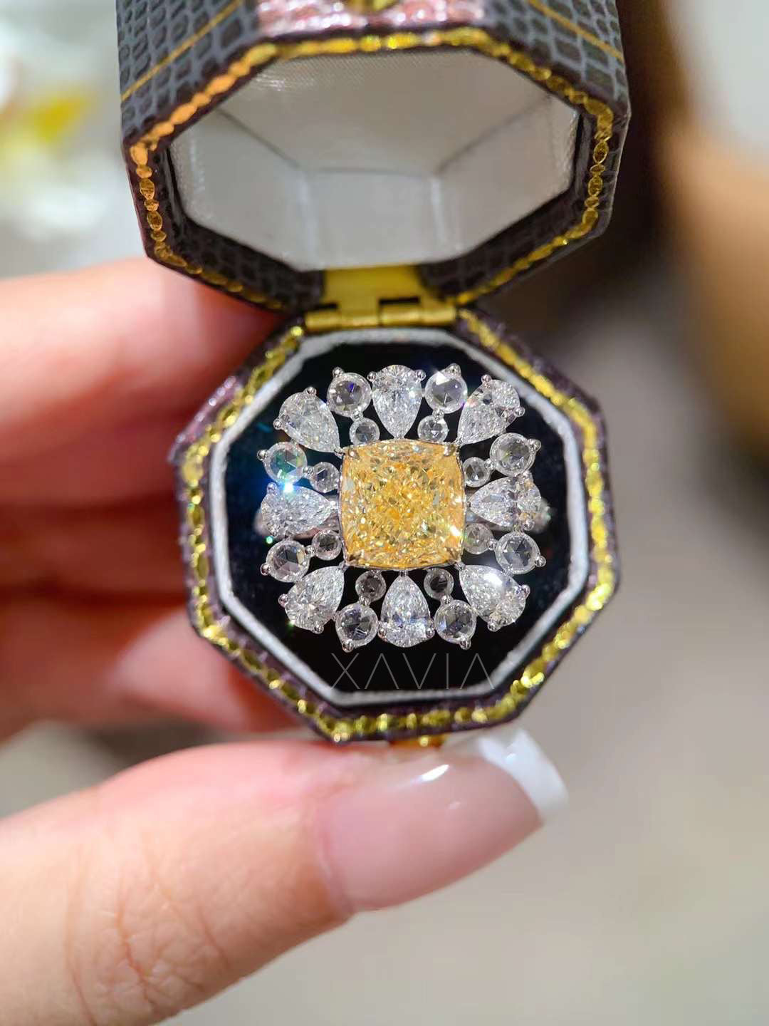 refined hand styling of fancy yellow cushion diamond cocktail ring with pear halo design, paired with other fine diamond accessories