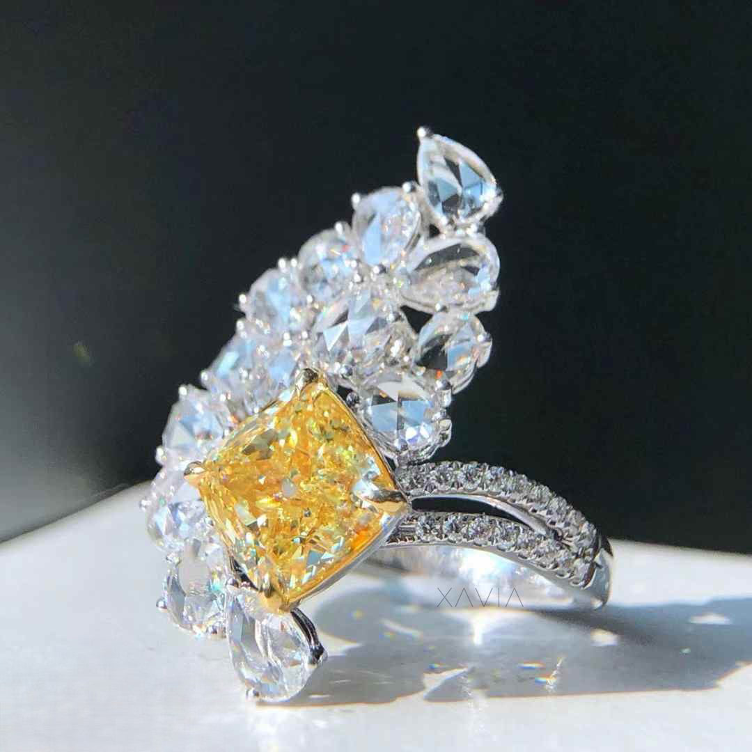 Model wearing large floral halo ring with yellow cushion lab diamond center and petal shaped marquise pear diamonds in pavé split shank setting