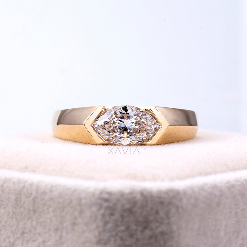 front angle view of marquise cut lab-grown diamond in polished yellow gold bezel engagement ring displayed on jewelry stand