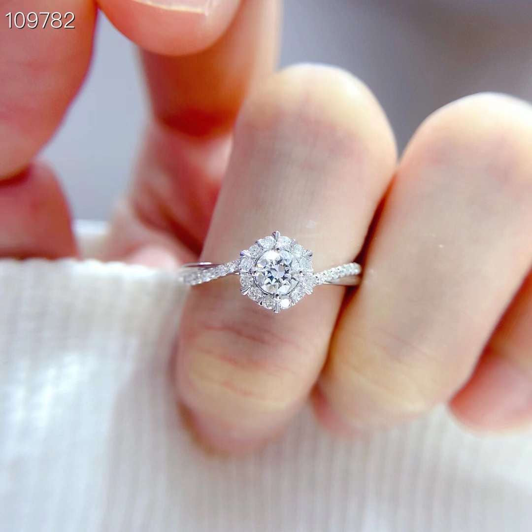 angled view of floral halo engagement ring highlighting marquise diamonds surrounding a round lab grown center stone