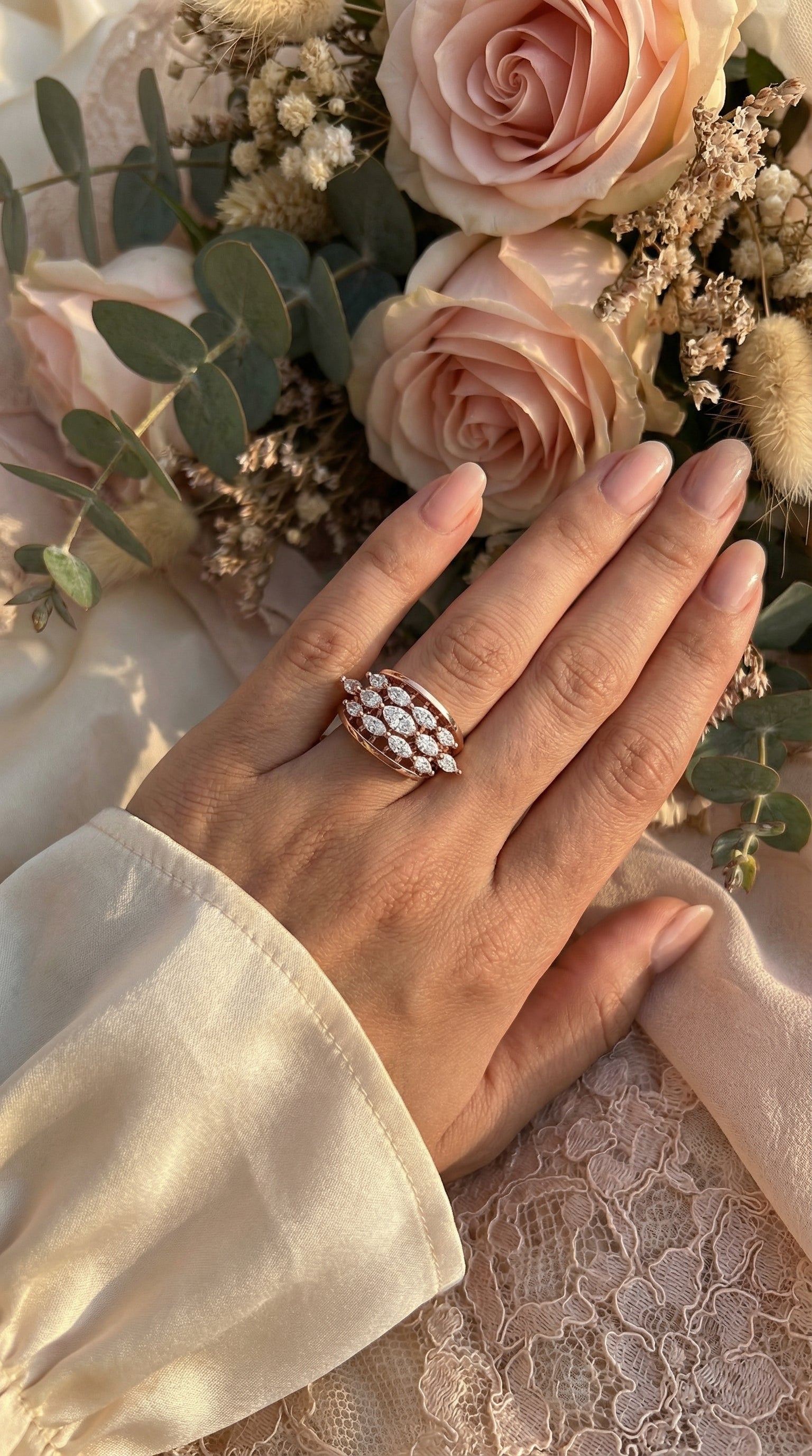 romantic styled photograph of marquise lab grown diamond lattice ring placed on silk pillow with flowers highlighting elegant jewelry design