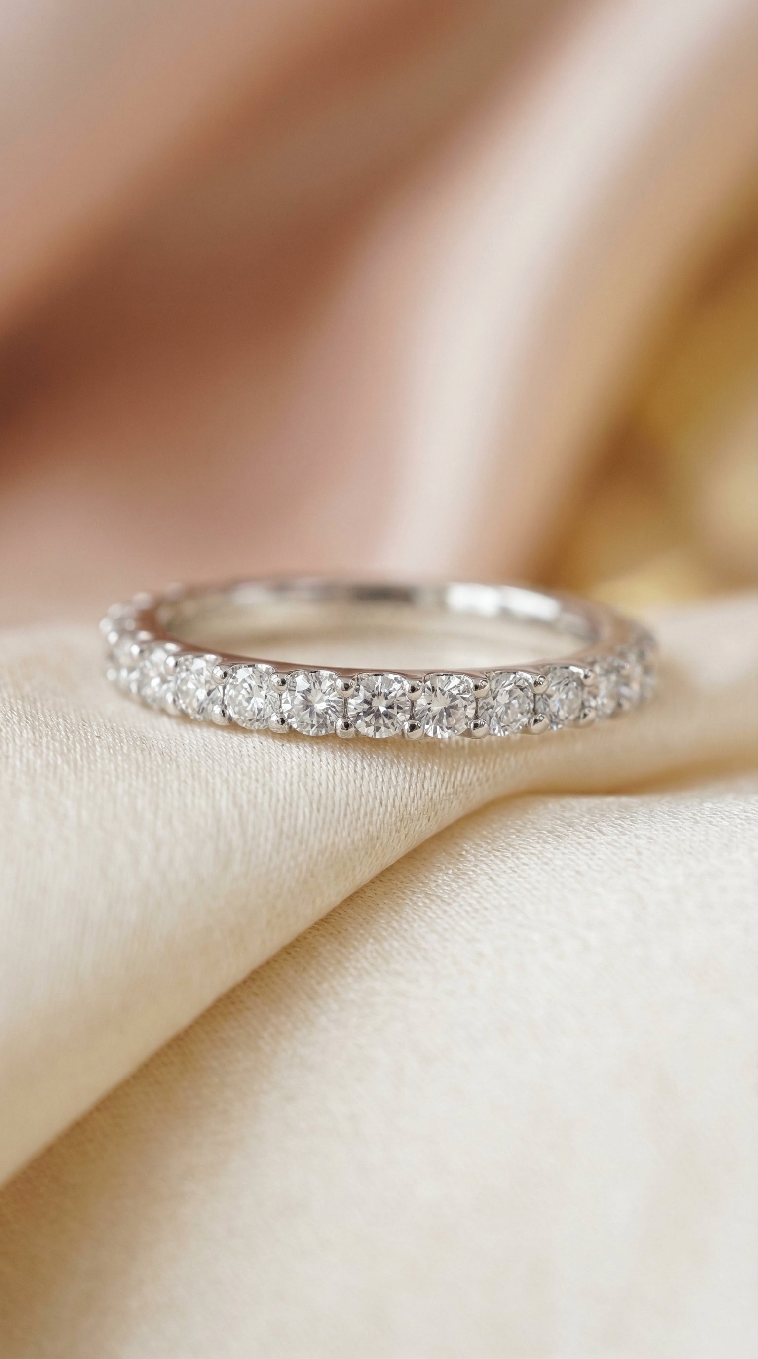 front view of slim round diamond wedding band with evenly spaced brilliant stones forming a refined half eternity row