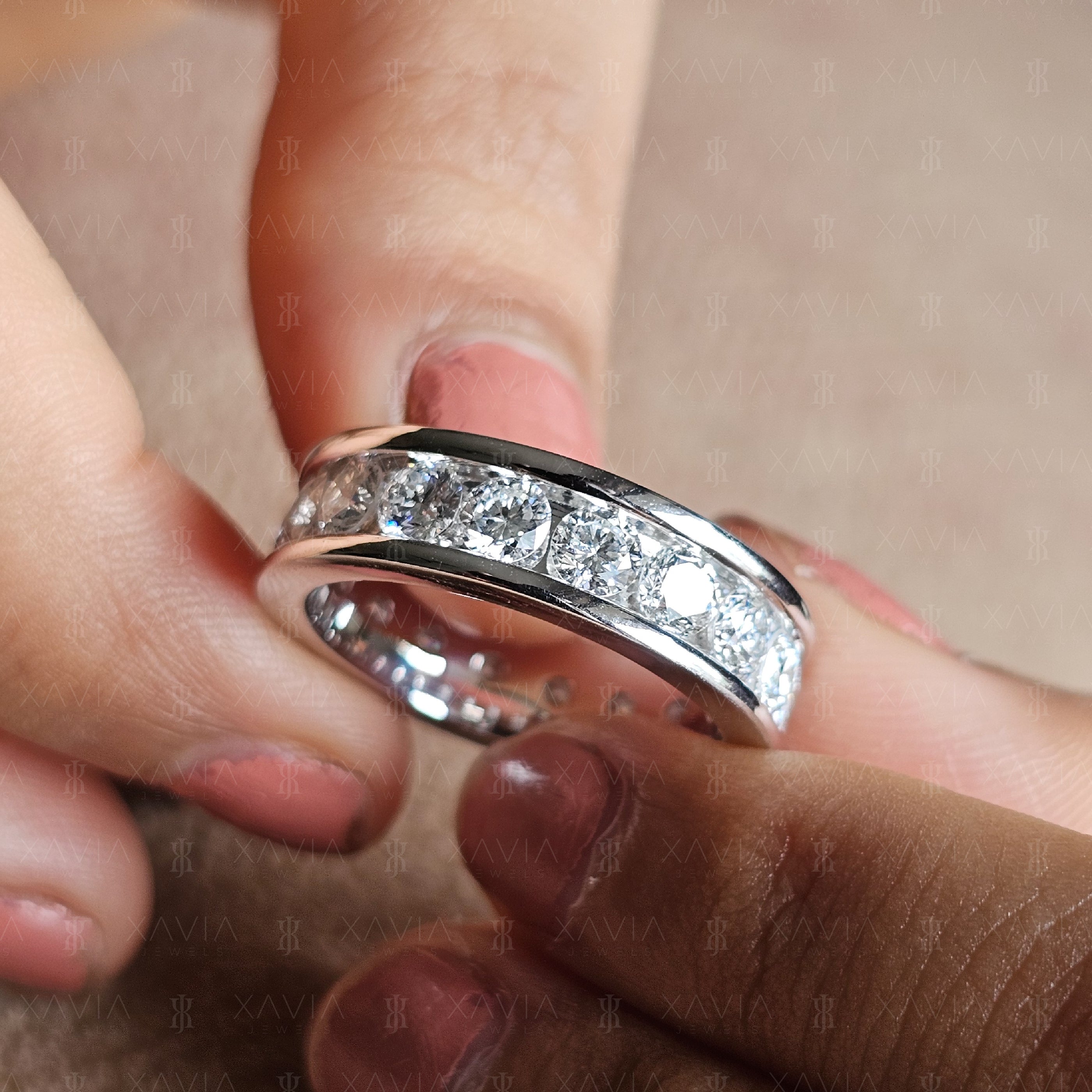 Detailed angled close-up of modern channel-set eternity ring with large round brilliant lab-grown diamonds and sleek polished edges