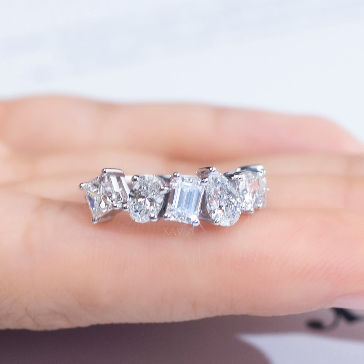 Hand holding multi-cut diamond band showing floating prong setting