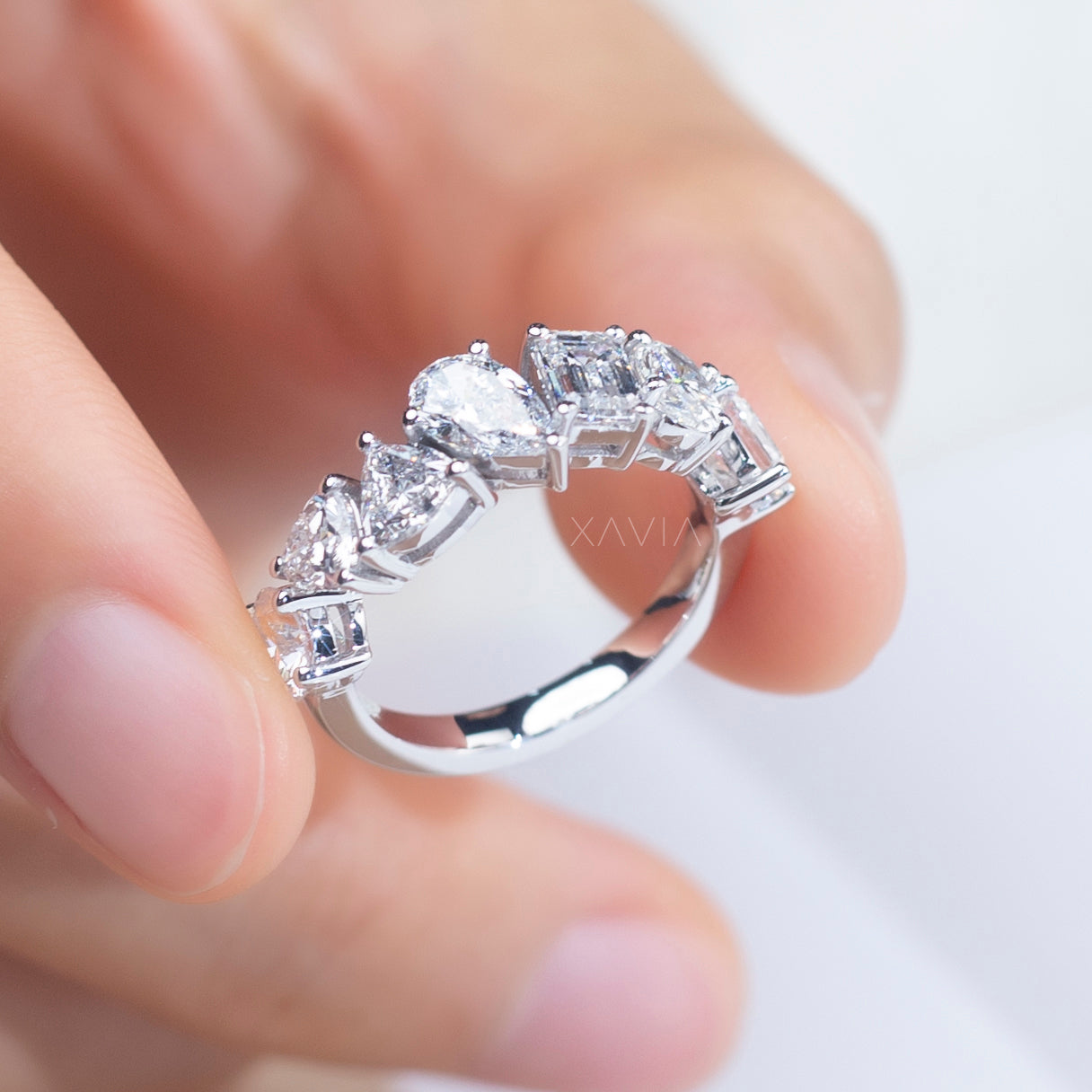 7-stone sculptural diamond ring displayed on finger in natural light