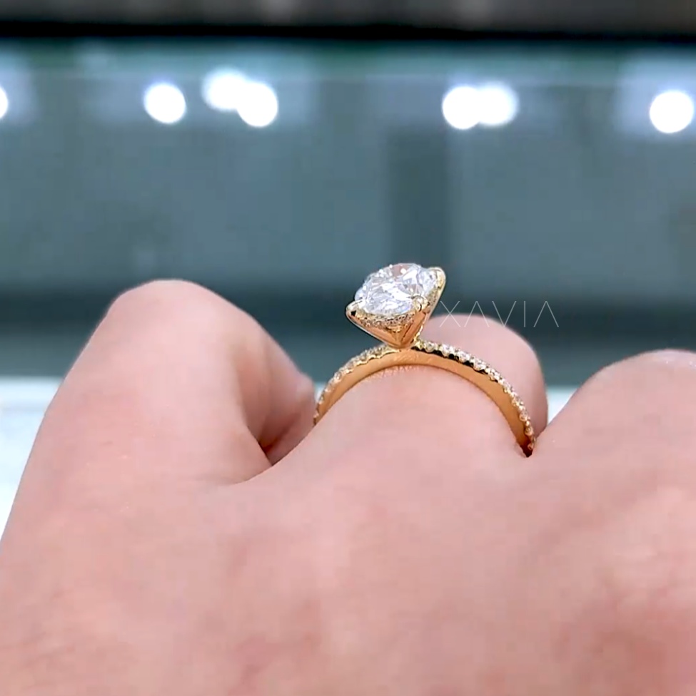 Side profile of yellow gold solitaire diamond ring showing pavé band and prong setting