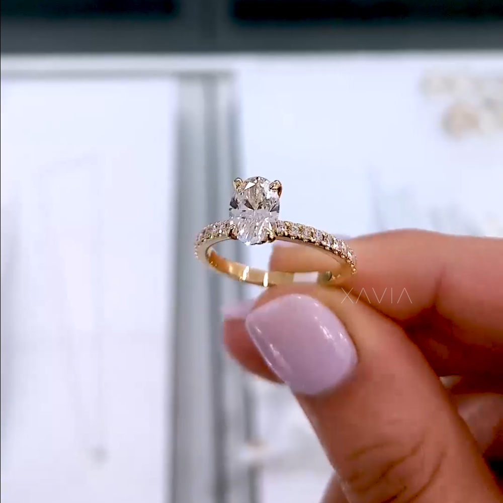 Side view of oval diamond engagement ring worn on finger, highlighting the raised setting