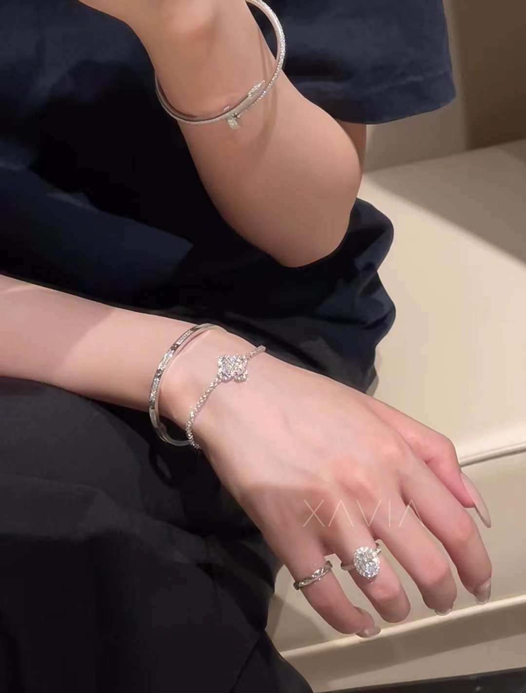 Oval cut lab-grown diamond engagement ring with halo setting and pavé band, styled with luxury white gold bangle on model’s hand