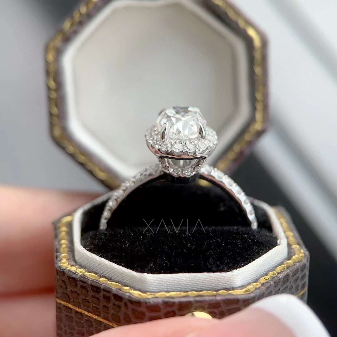 Angled view of oval lab grown diamond halo engagement ring showing elevated center diamond, halo setting and pavé diamond band inside jewelry presentation box