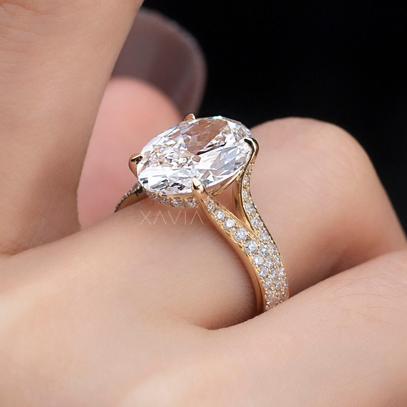Side profile of oval lab diamond engagement ring featuring cathedral setting, hidden halo detail beneath center stone and pavé diamonds along the split shank band