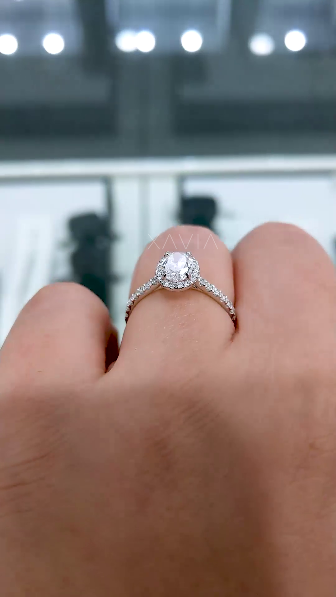 angled side profile of oval halo lab diamond engagement ring showing raised setting, prongs and fine pavé detailing along band
