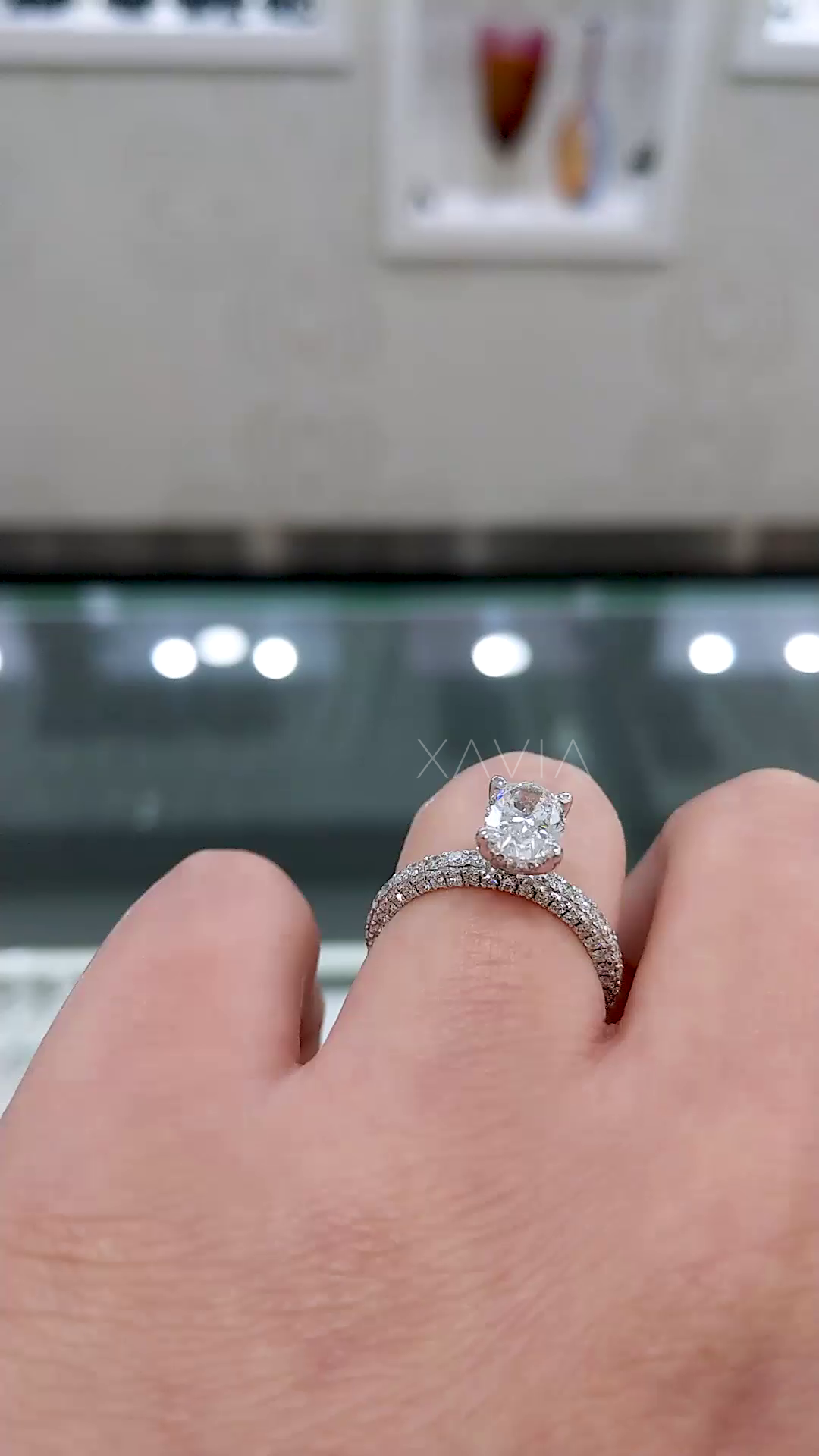 top view of oval cut lab diamond ring featuring four prong setting and micro pave diamond band with refined symmetrical design