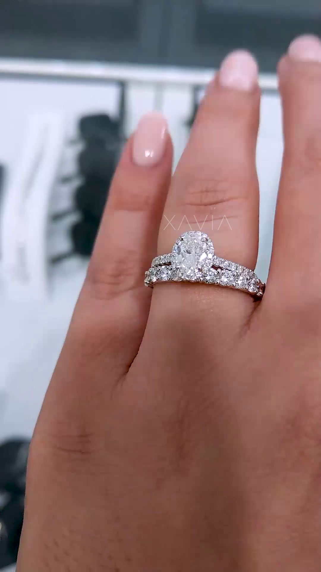 perspective shot of oval cut lab diamond halo ring worn on finger highlighting finger coverage, sparkle and elegant minimal band