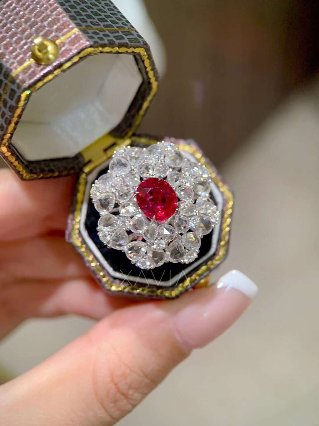 Luxury oval ruby center cocktail ring surrounded by brilliant round lab grown diamonds in a dramatic floral halo cluster displayed inside a vintage jewelry box