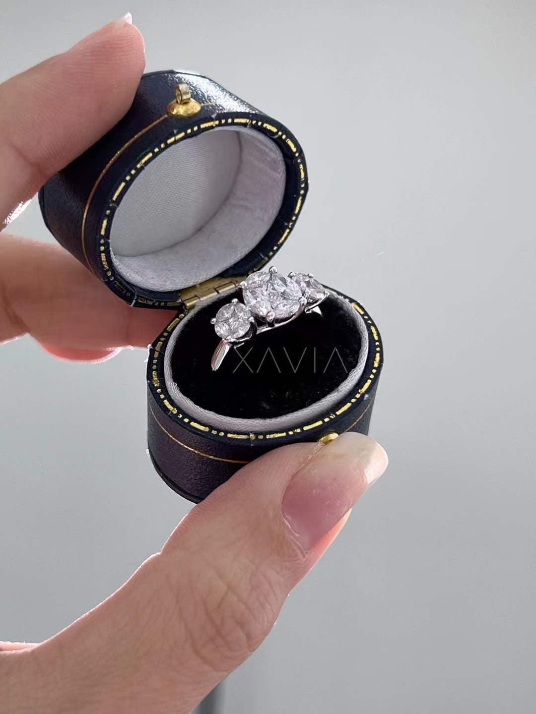 Side view of oval cut three stone lab grown diamond engagement ring highlighting elevated claw setting and polished precious metal band