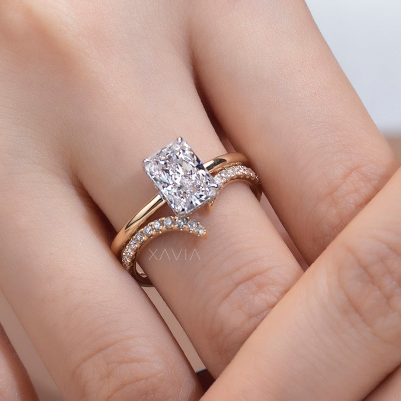Close-up detail of pavé set crescent shoulders and radiant cut center diamond in modern open bypass ring