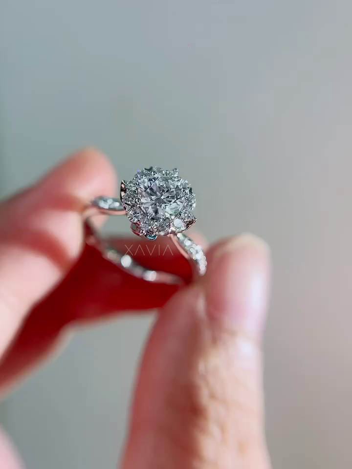 Angled perspective of halo diamond engagement ring highlighting pavé-set diamonds along the cathedral band and bright round center stone