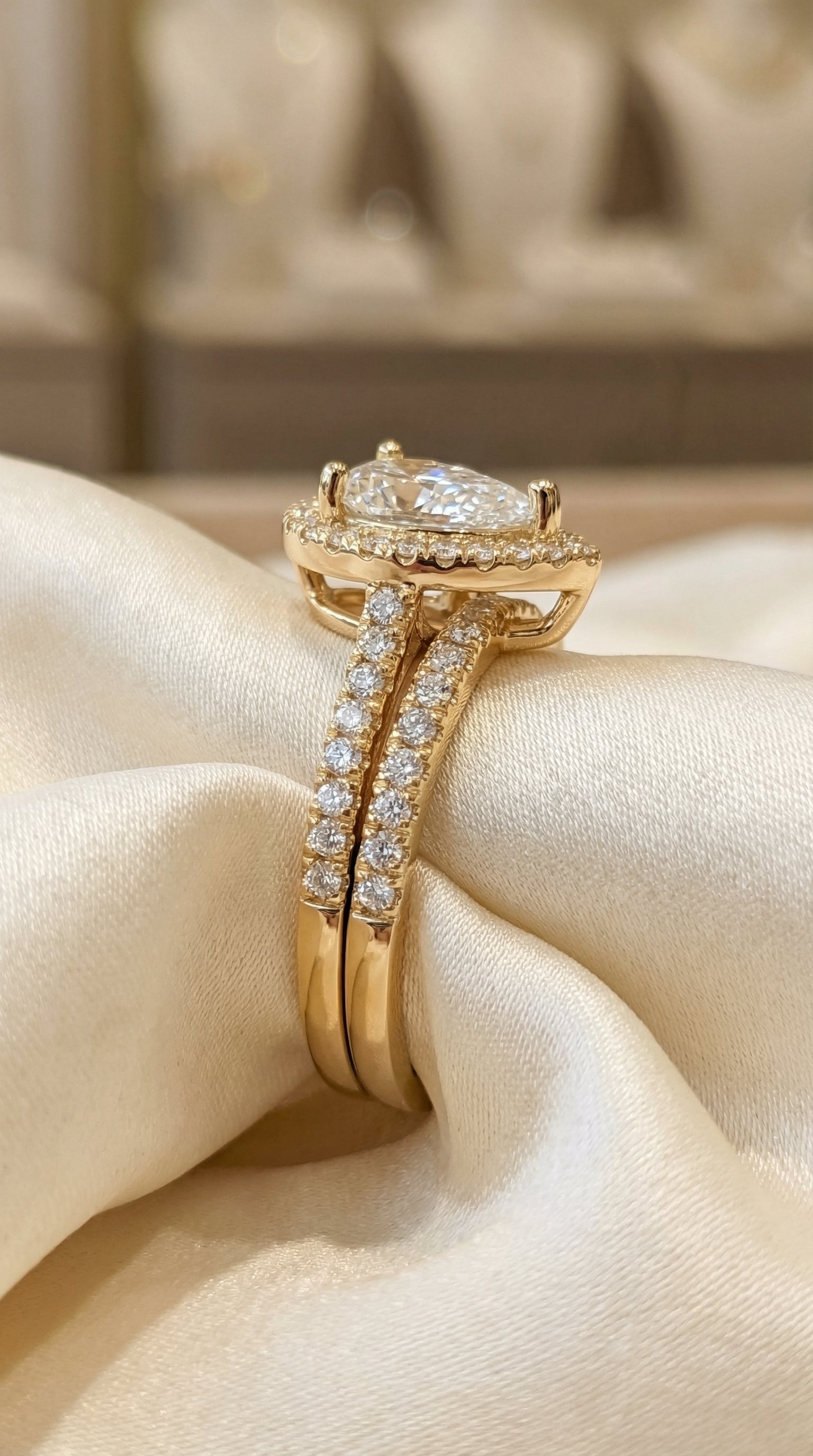 Close side profile of pear cut lab grown diamond halo engagement ring with double pavé split shank in yellow gold showing elevated four prong setting and brilliant halo diamonds