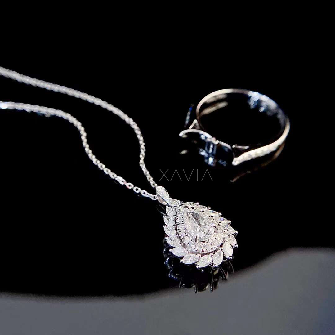 luxury pear cut lab grown diamond halo engagement ring with marquise floral frame photographed on black reflective background