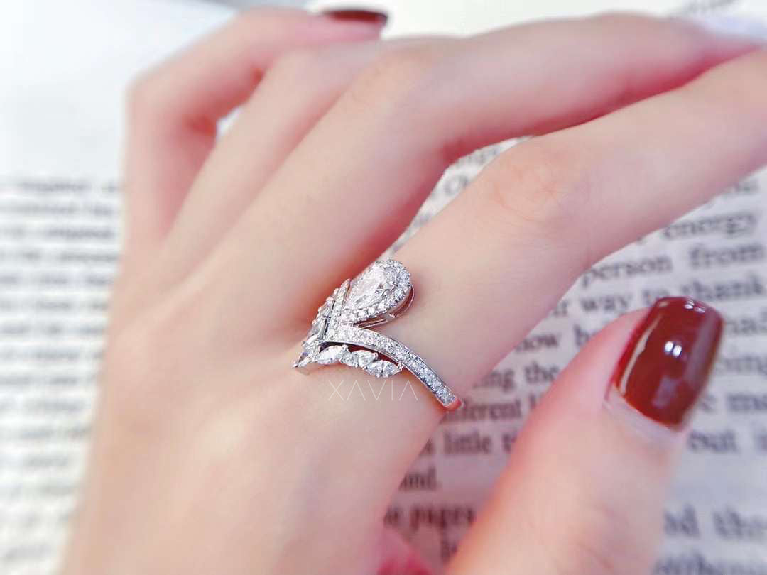 Side profile of pear shaped lab diamond halo ring highlighting raised center setting and pavé bypass band