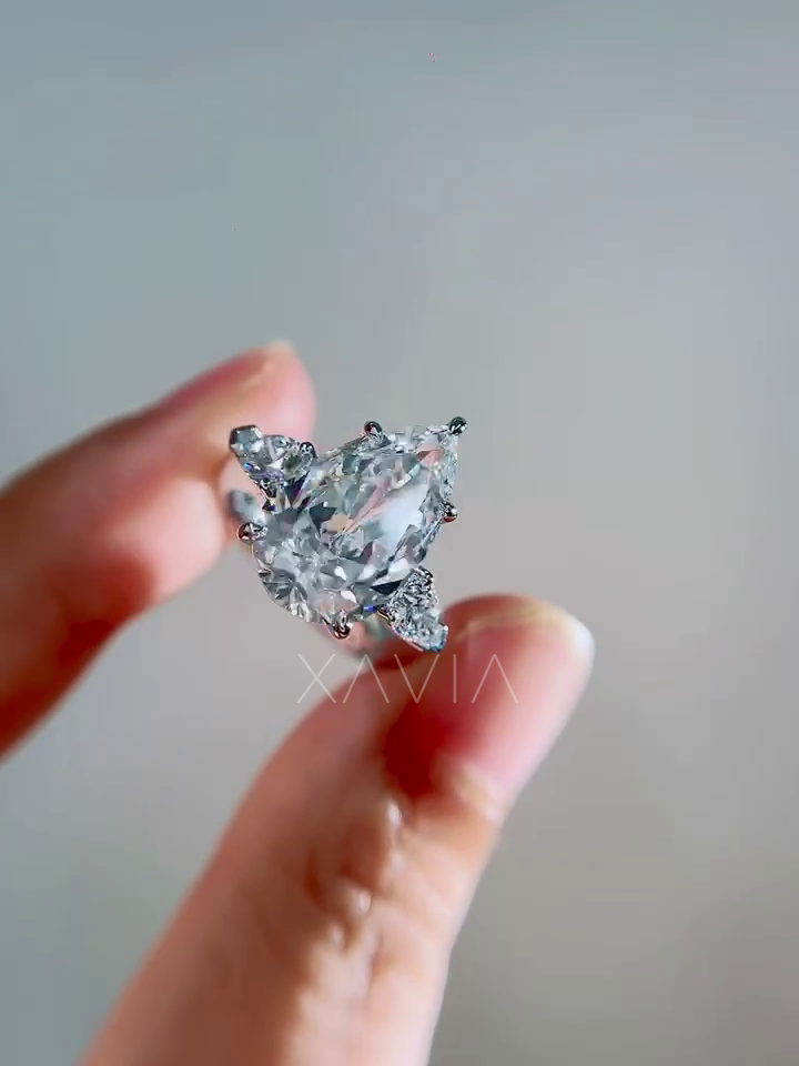 top view of pear shaped lab grown diamond engagement ring with trillion side diamonds creating elegant three stone bridal design