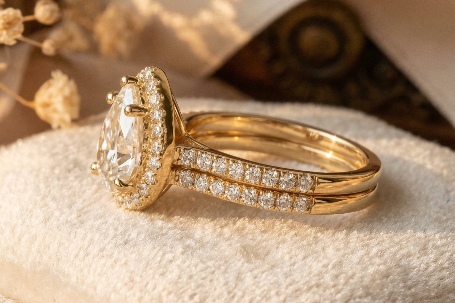 Angled side view of pear shaped lab diamond halo engagement ring with pavé split shank band in yellow gold highlighting halo sparkle and elegant bridge structure