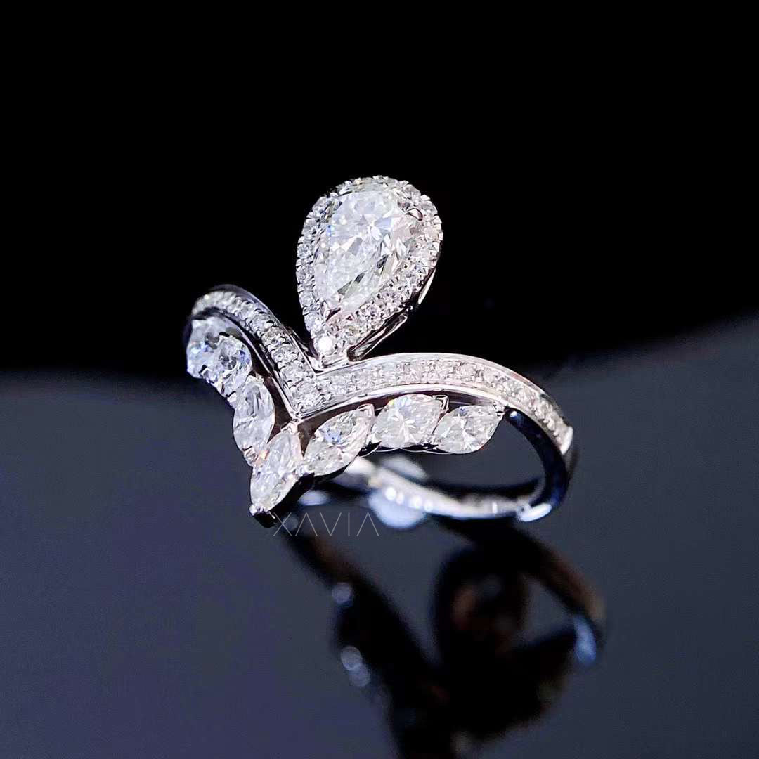 Luxury pear cut lab diamond engagement ring with delicate halo and flowing marquise diamonds in modern sculptural design
