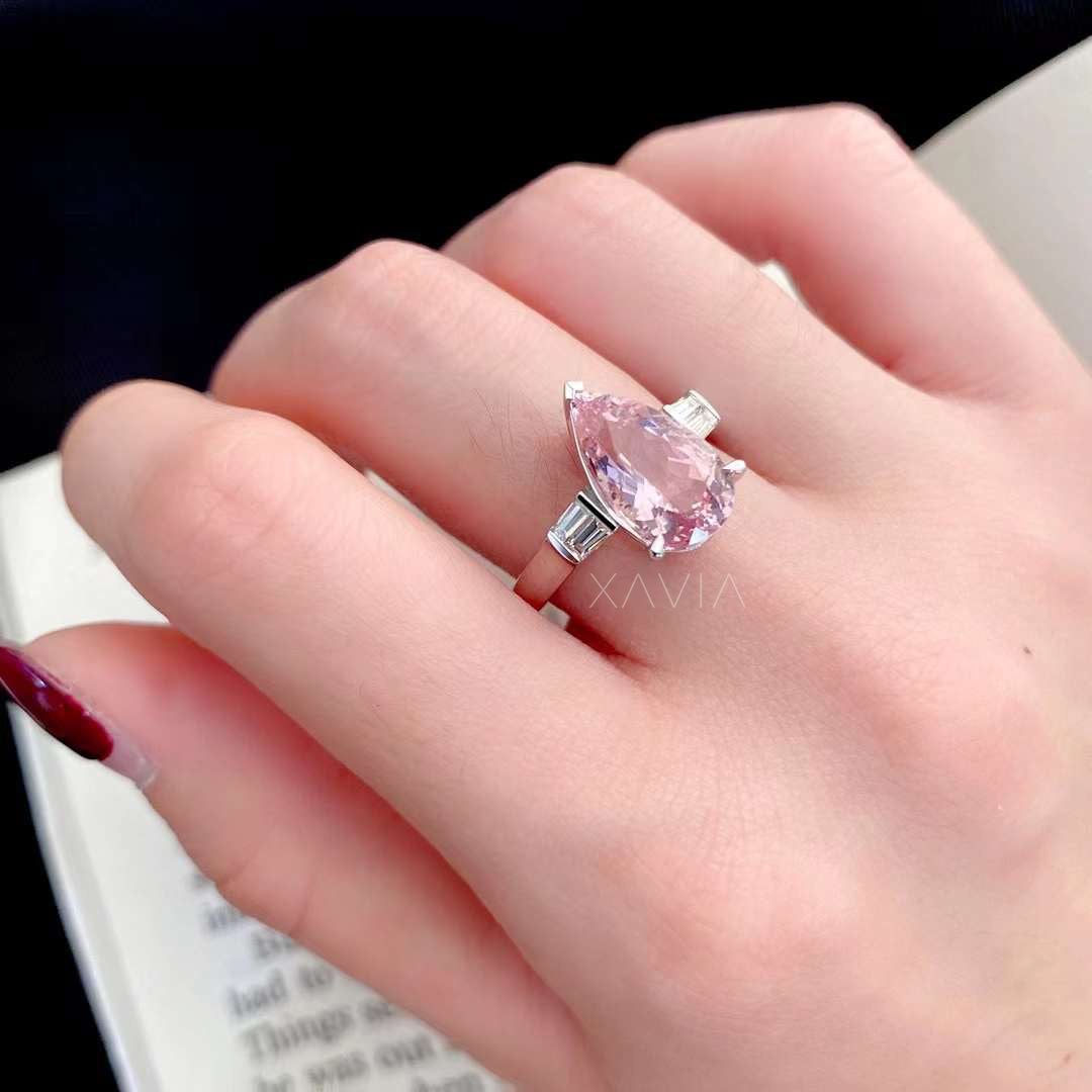 Top view of pear cut pink morganite center stone engagement ring with tapered baguette lab diamond side stones and high polish white gold setting
