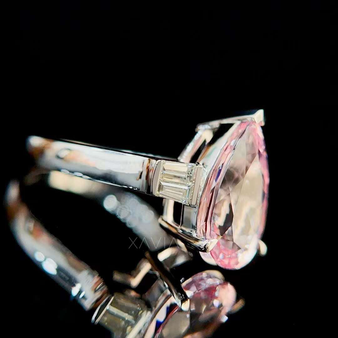  Detailed gallery view of pear shaped pink morganite engagement ring with structured basket setting and elegant tapered baguette diamonds