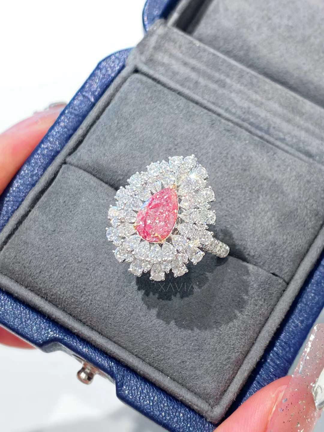 Pear cut pink lab diamond ring displayed in a luxury jewelry box, featuring a double marquise halo and high-polish white gold setting