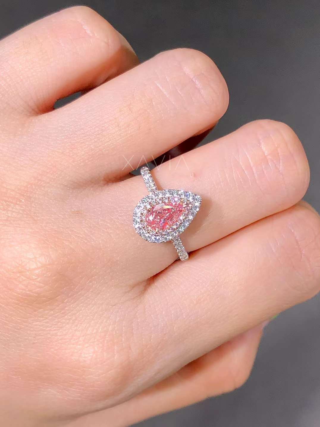 high-polish white gold ring with pink pear center and halo on finger