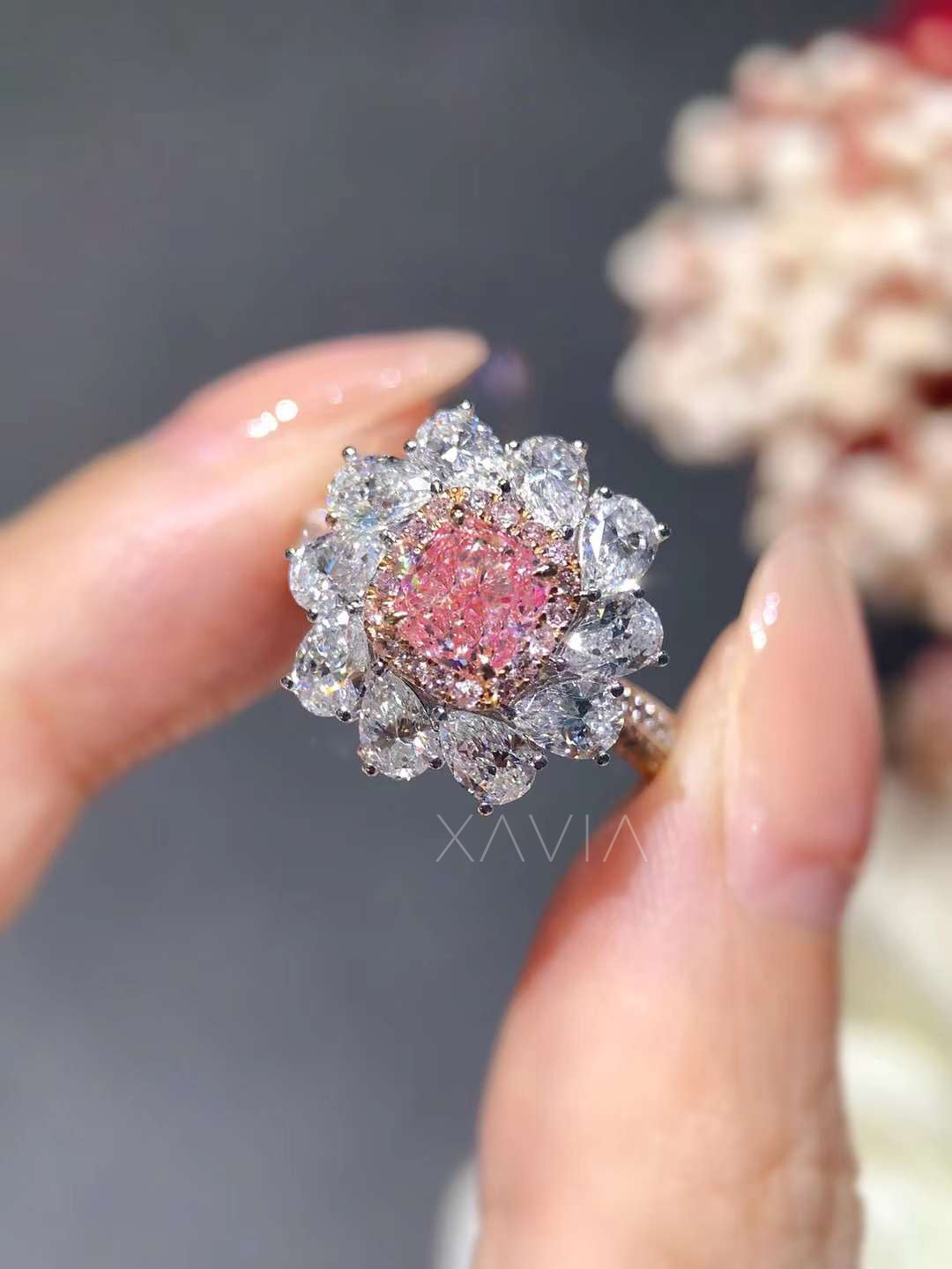 close-up of cushion cut pink diamond ring with white pear halo