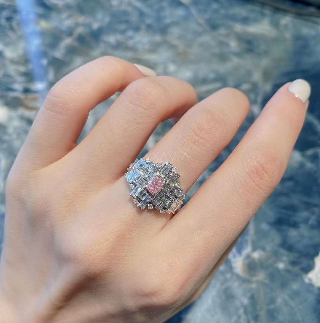 luxury pink emerald diamond cluster ring with baguette and round accents worn on model’s hand