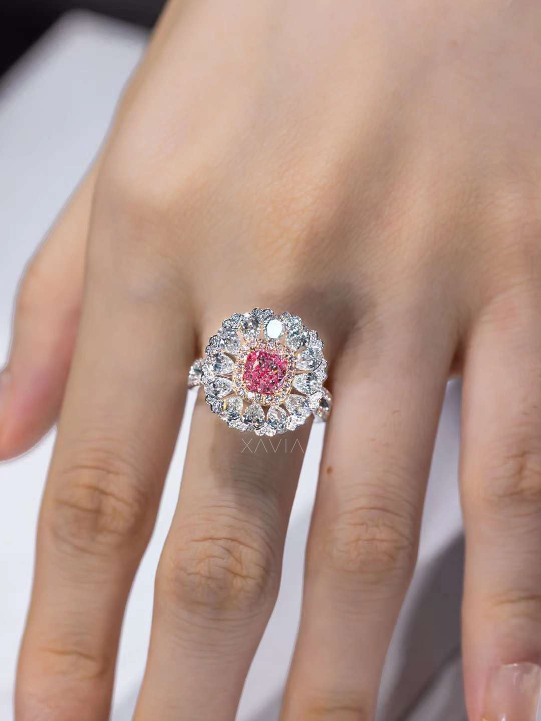 cushion pink diamond engagement ring with floral halo setting shown worn on hand