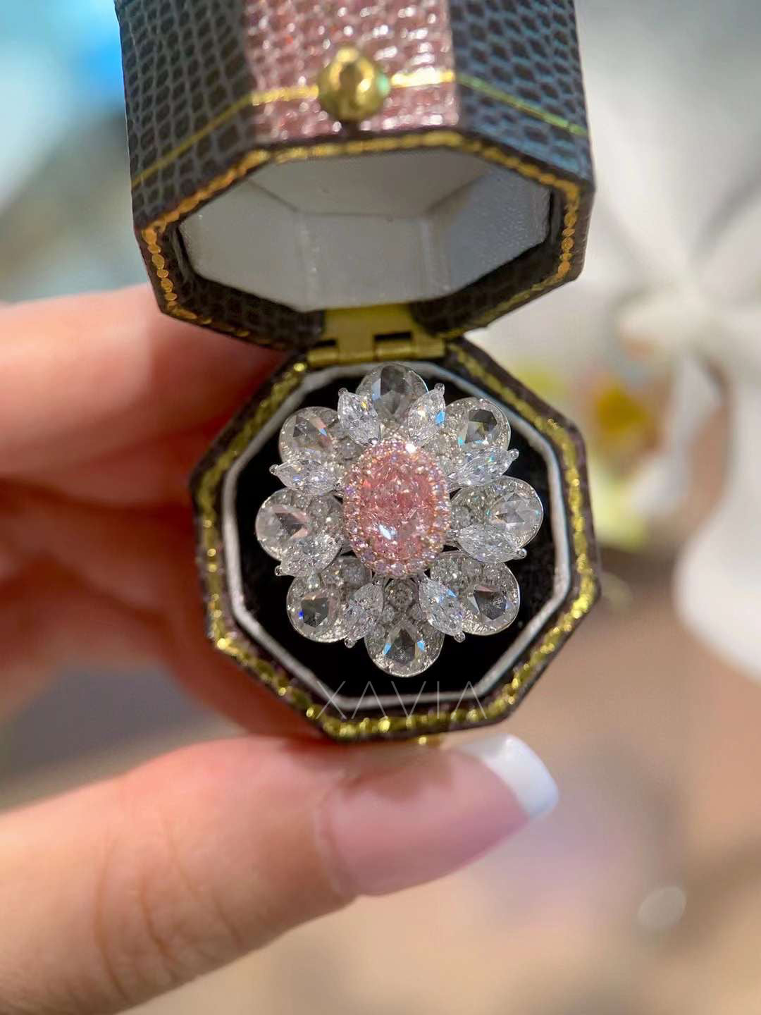 close-up of pink oval diamond floral cocktail ring with marquise and pear cut halo