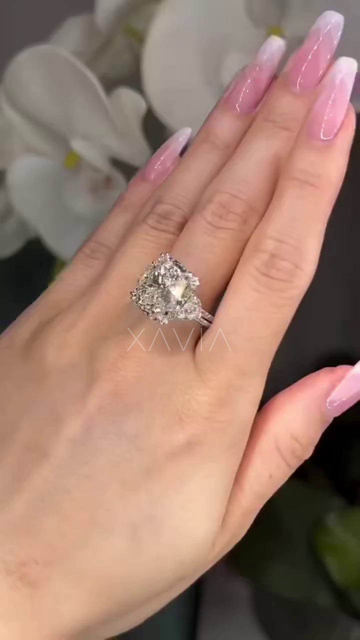 platinum cushion cut three stone diamond engagement ring with pavé band showcased on model’s hand
