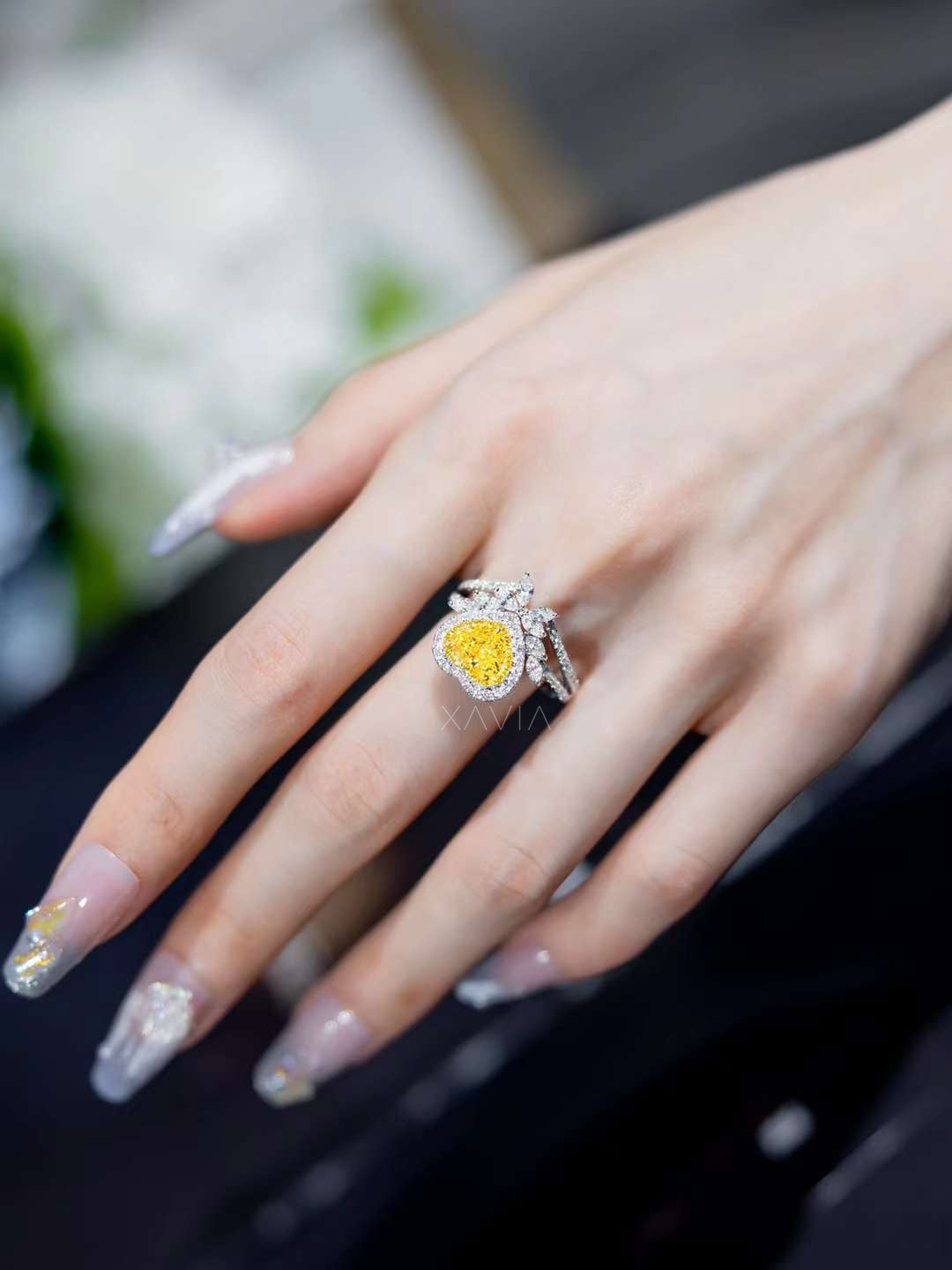 platinum engagement ring featuring fancy yellow heart diamond with halo and floral marquise white diamond details