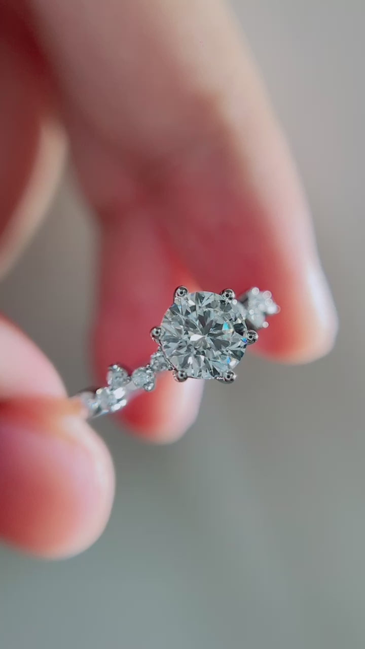 Round brilliant DEF color lab-grown diamond center with VVS–VS clarity, accented by marquise and round diamonds on an elegant nature-inspired vine band.